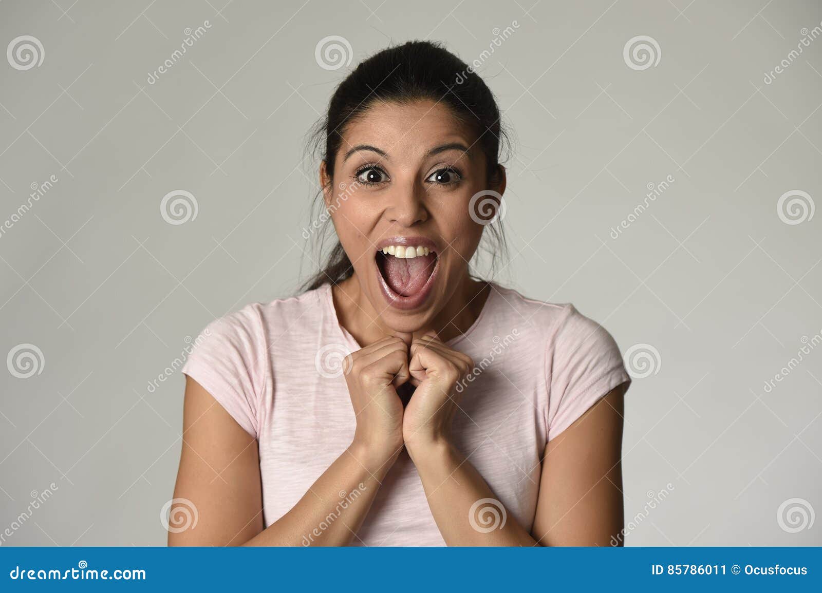 beautiful spanish surprised woman amazed in shock and surprise happy and excited