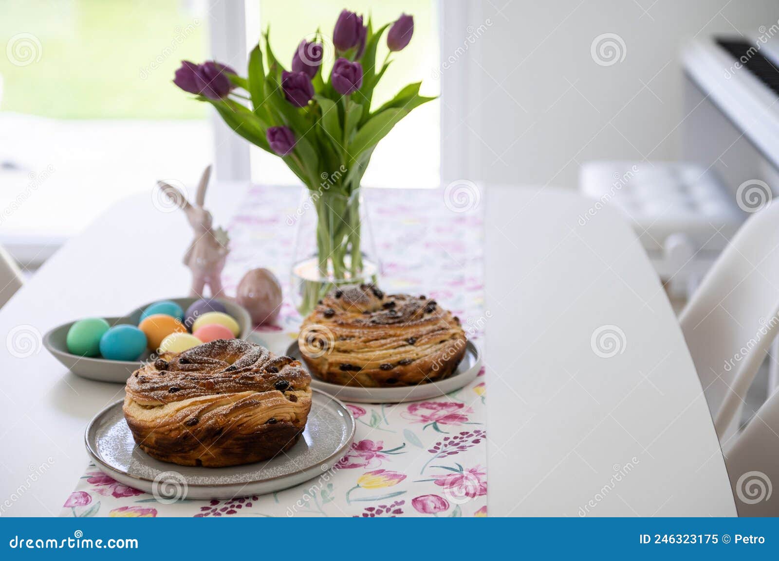 beautiful spring table with paska or kulich, tulip and colorful easter eggs