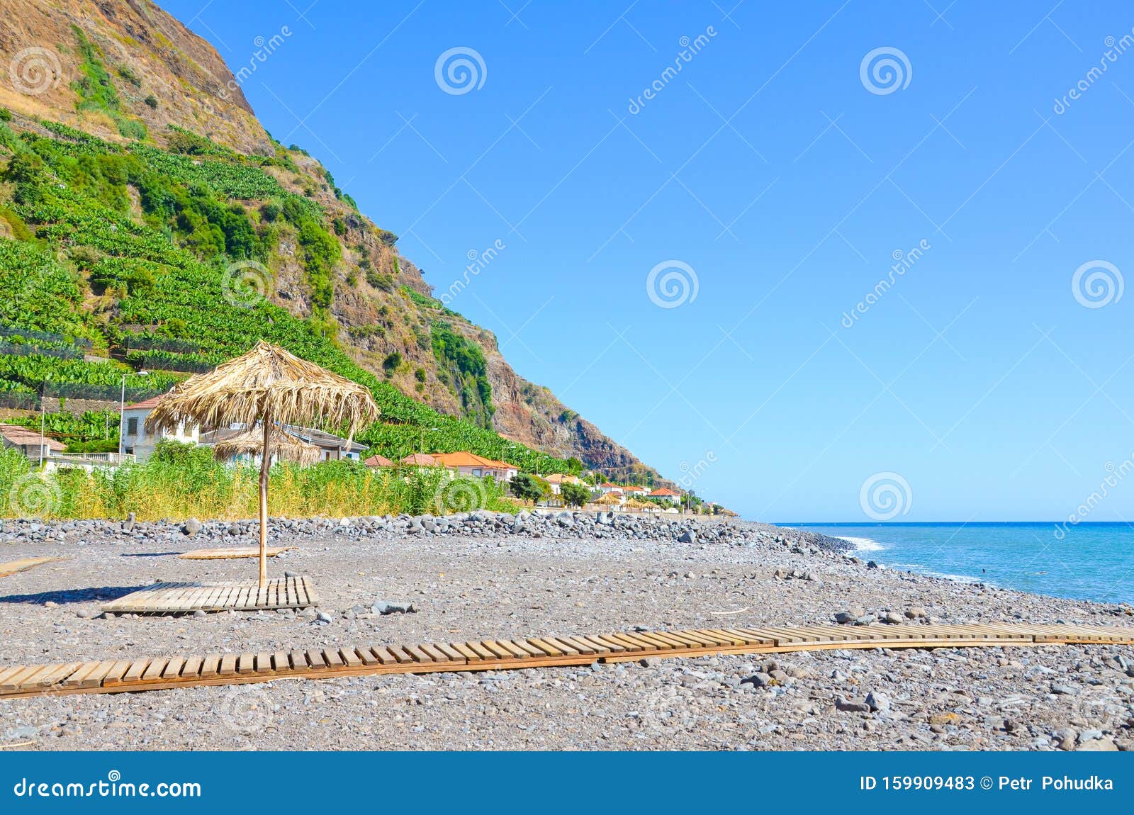 beautiful stone beach in madalena do mar, madeira, portugal photographed in the late summer on a sunny day. hill with banana