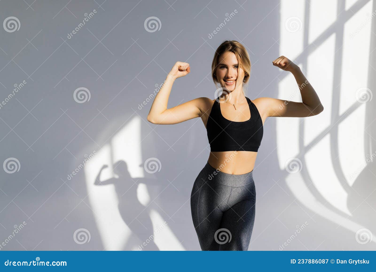 Strong Beautiful Fitness Woman Flexing Her Arm and Back Muscles