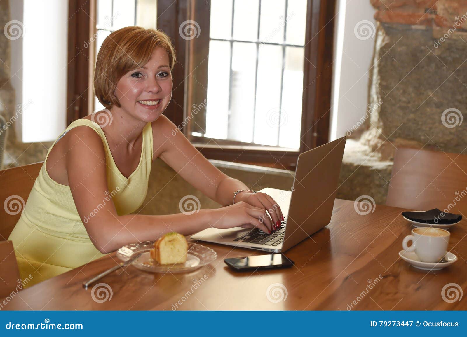 beautiful successful woman working at coffee shop with laptop computer enjoying coffee cup