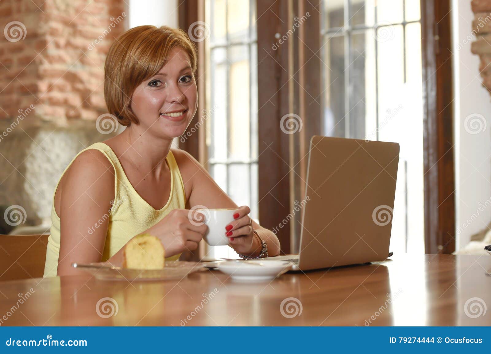 beautiful successful woman working at coffee shop with laptop computer enjoying coffee cup