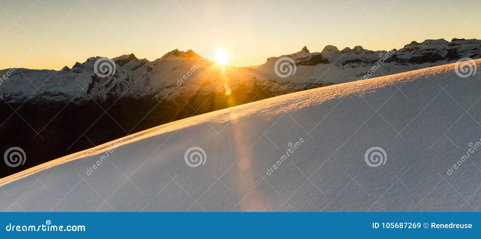 beautiful sunrise in snowy mountain landscape. sunbeams illuminating unspoiled powder snow. alps, switzerland.