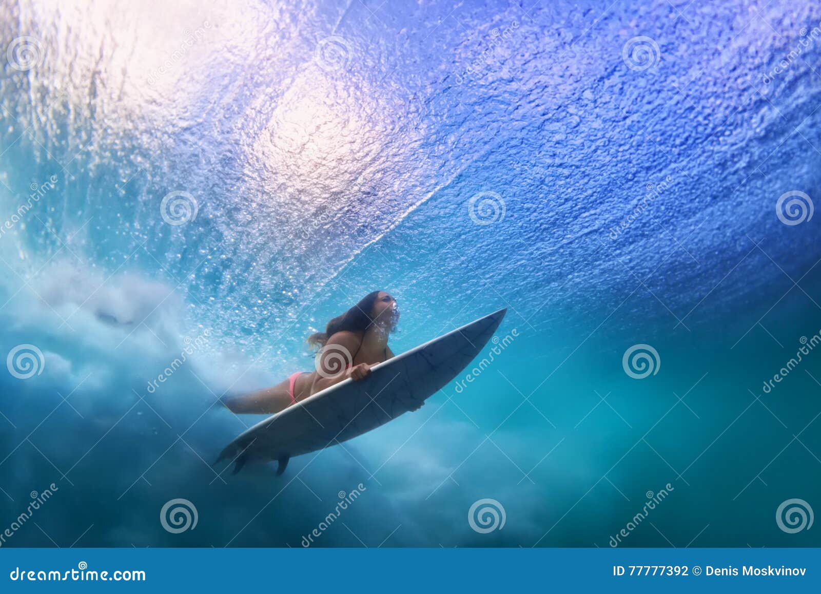 beautiful surfer girl diving under water with surf board