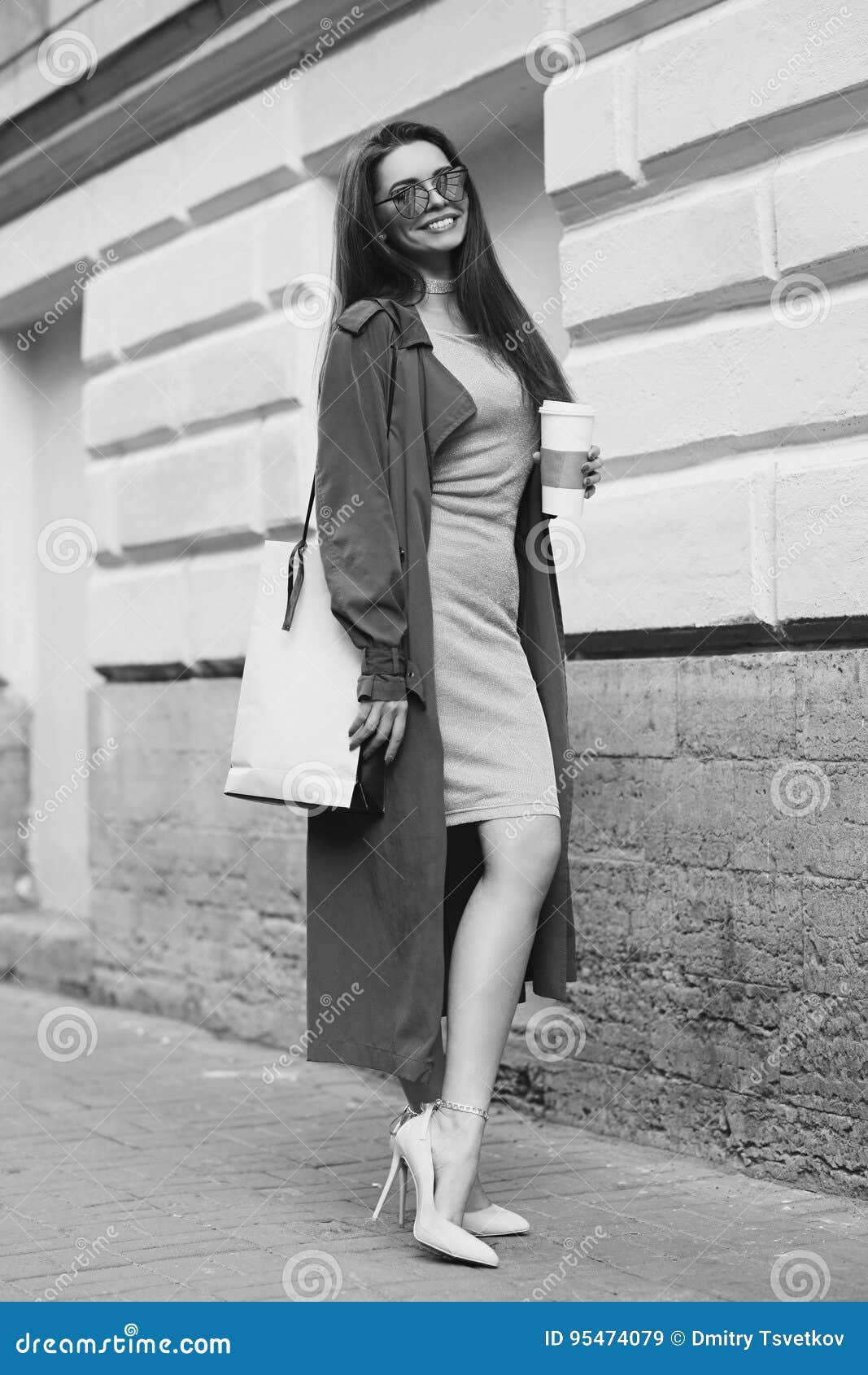 Young Beautiful Stylish Woman With Long Straight Brunette Hair Walking At  The Street. Pretty Girl In Pink Elegant Dress And Coat Holding Shopping Bag  And Cup Of Coffee. Stock Photo, Picture and