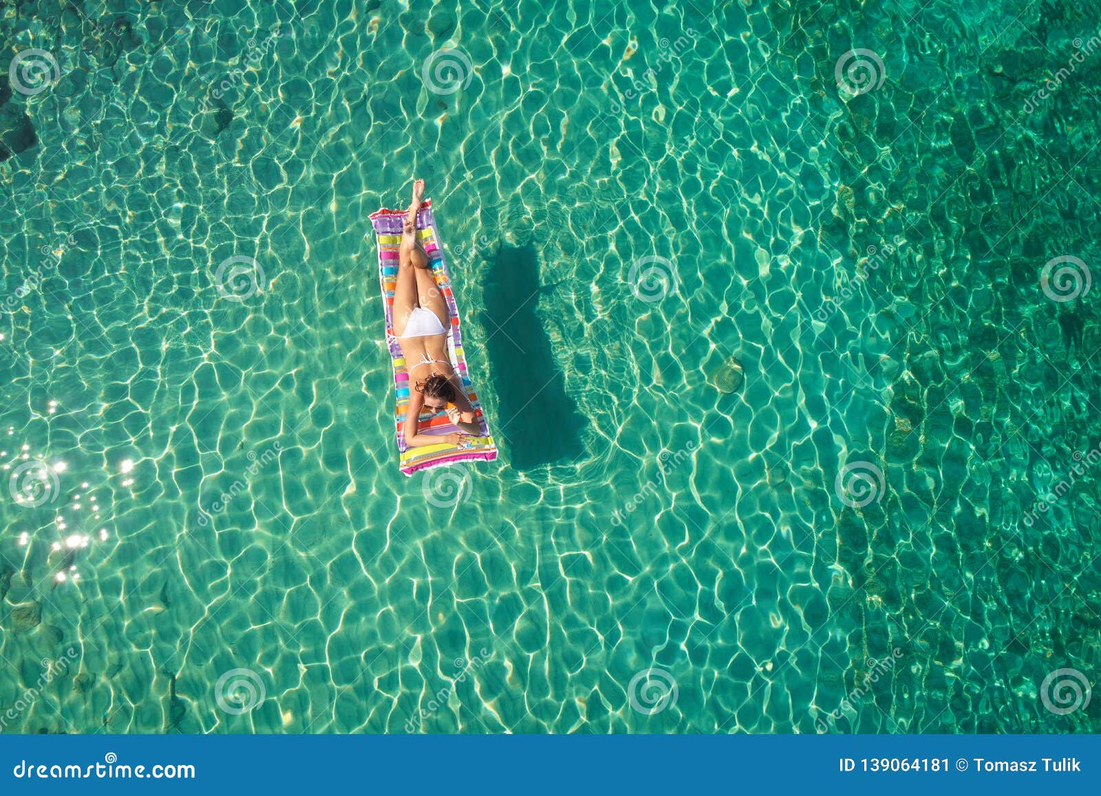 Beautiful Tanned Girl in a Bikini Sitting on a Rocky Beach Stock Image ...