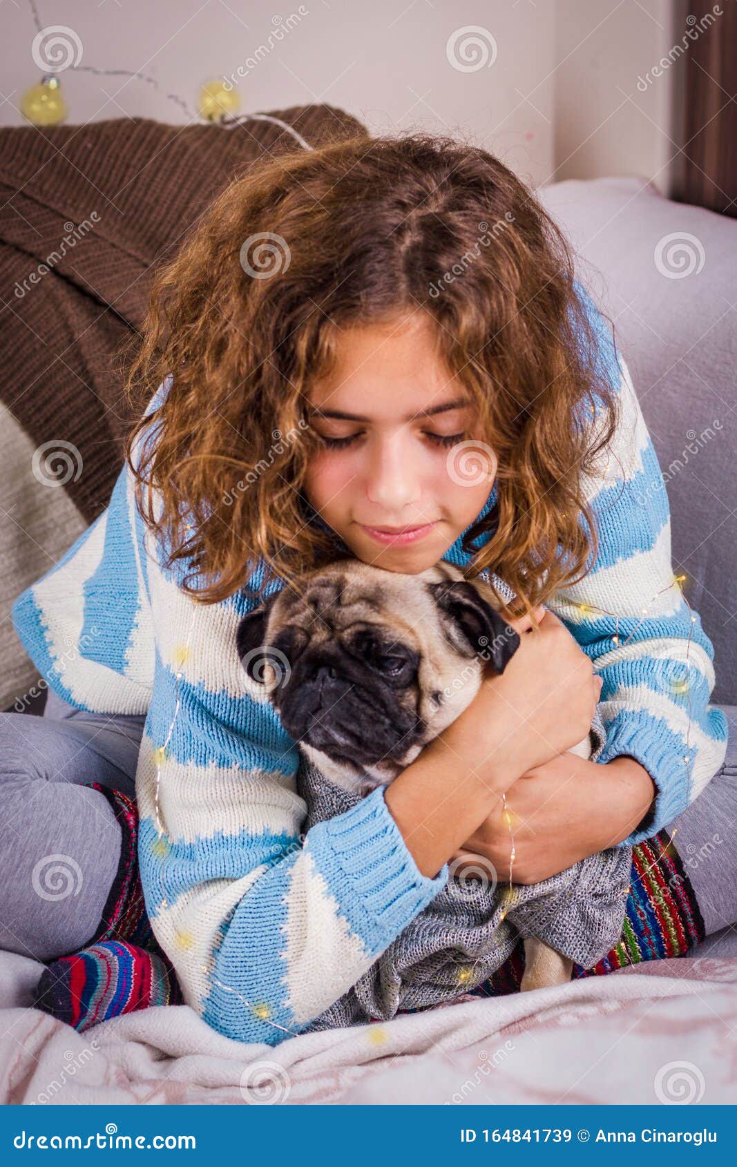 Beautiful Teen Girl Hugs a Pug Dog with Love. Curly Girl in a Knitted ...