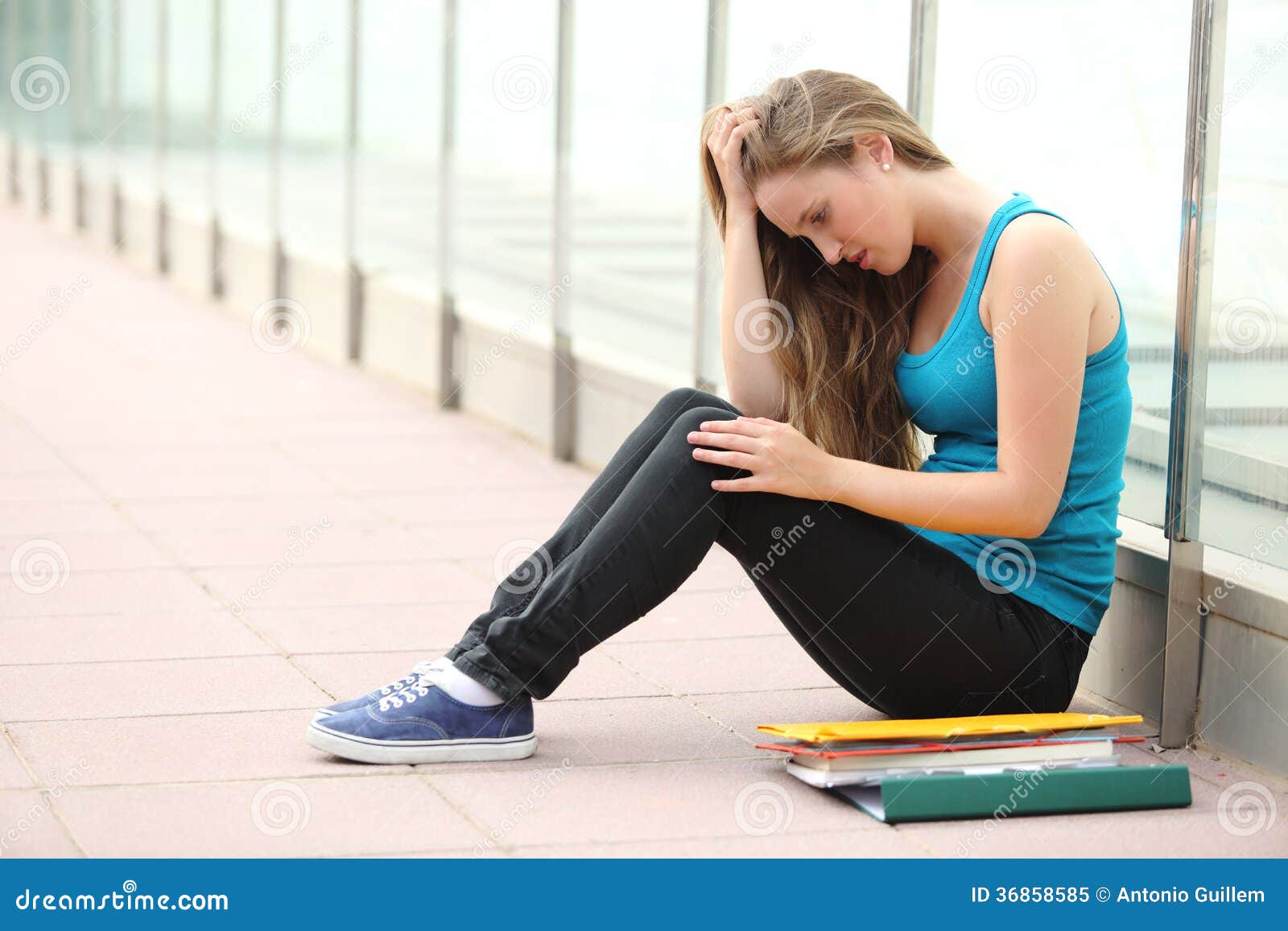 beautiful teenager girl depressed sitting on the floor outdoor