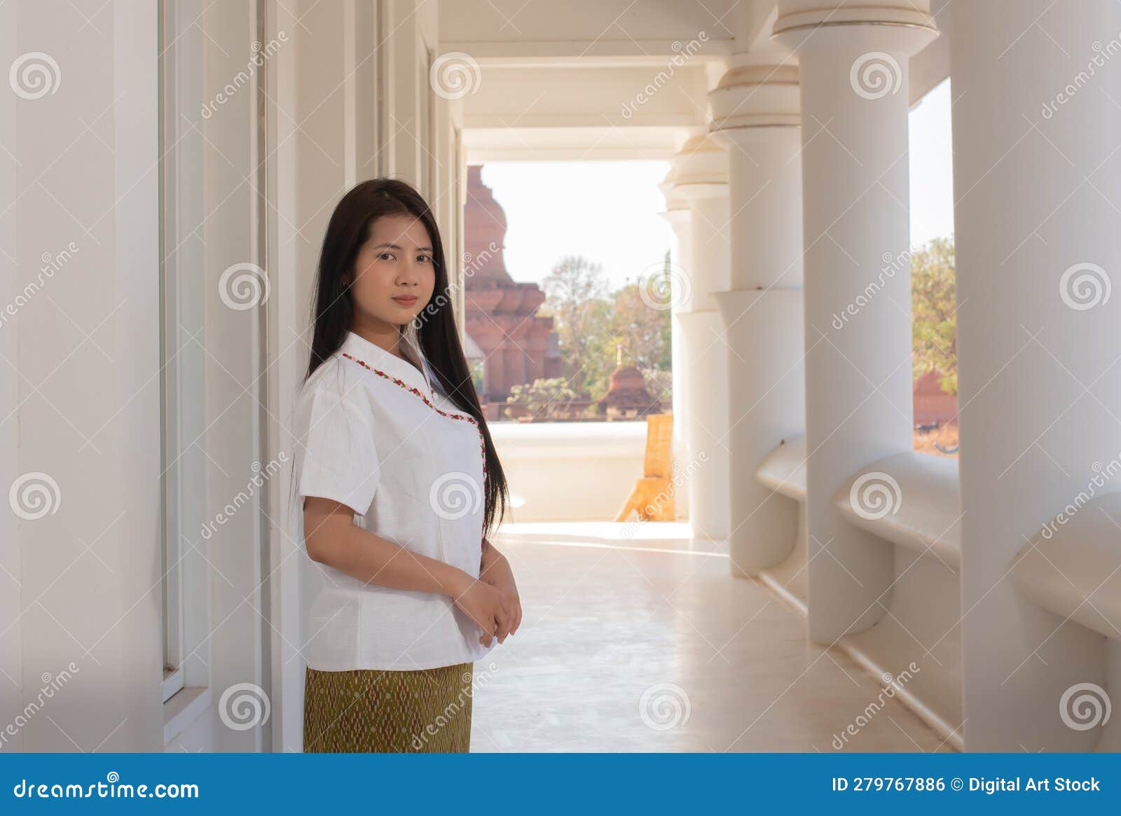 beautiful thai woman in a white traditional thai dress is standing in white temple with smilingly face