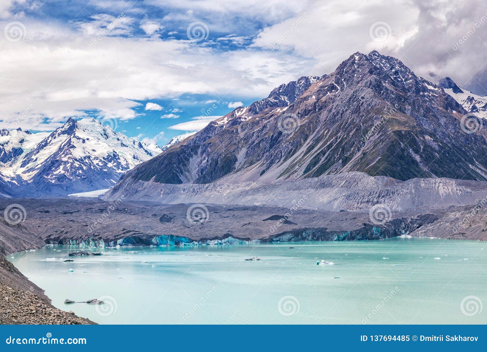 beautiful turqouise tasman glacier lake and rocky mountains in the clouds