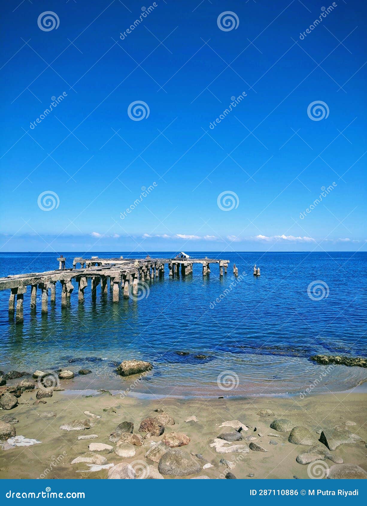 beautiful view of a pier on a beach with the blue sea in summer