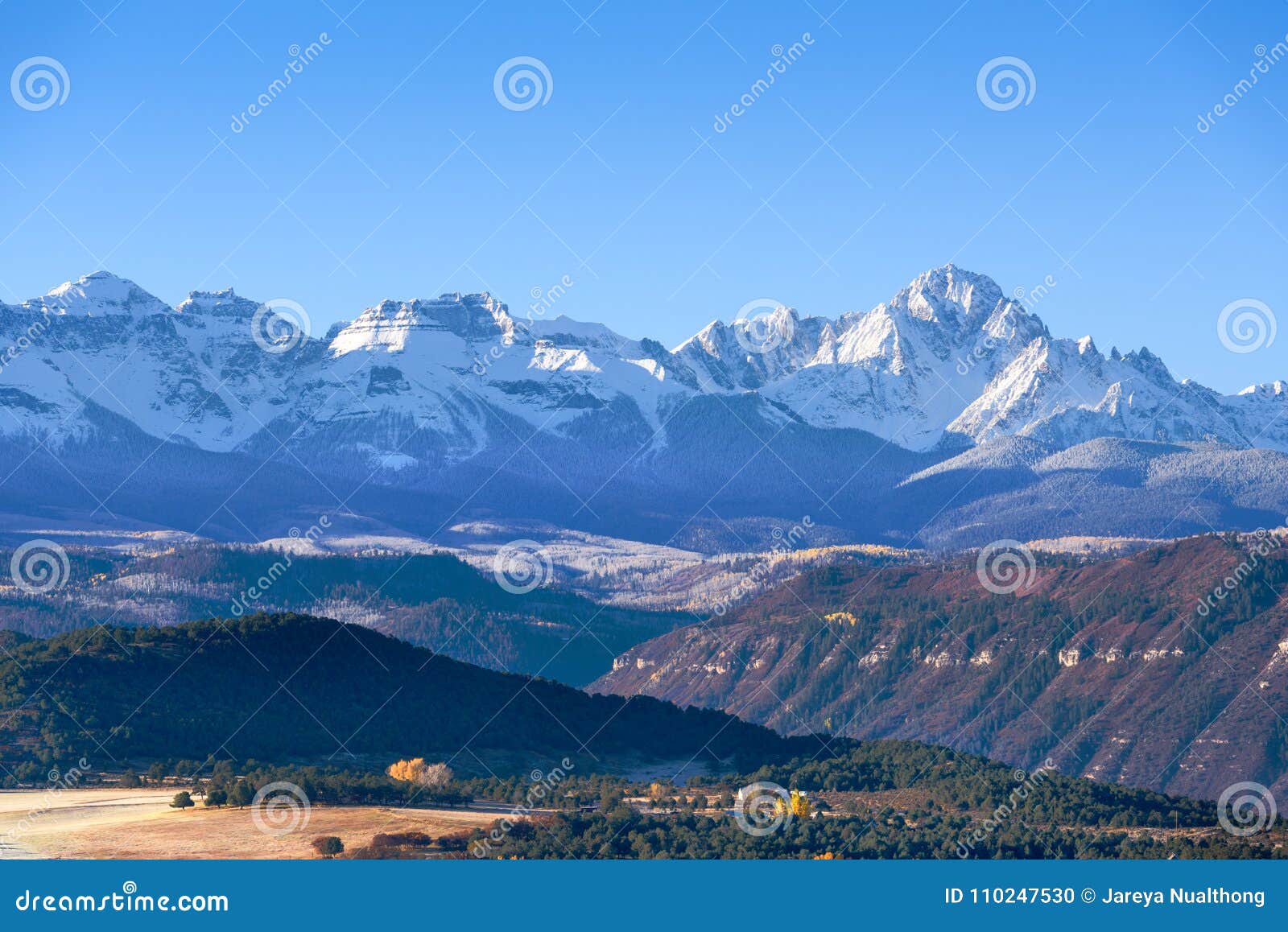 beautiful view of snow covered sneffels range in a bright daylight blue sky in the morning light near ridgway, colorado, usa.