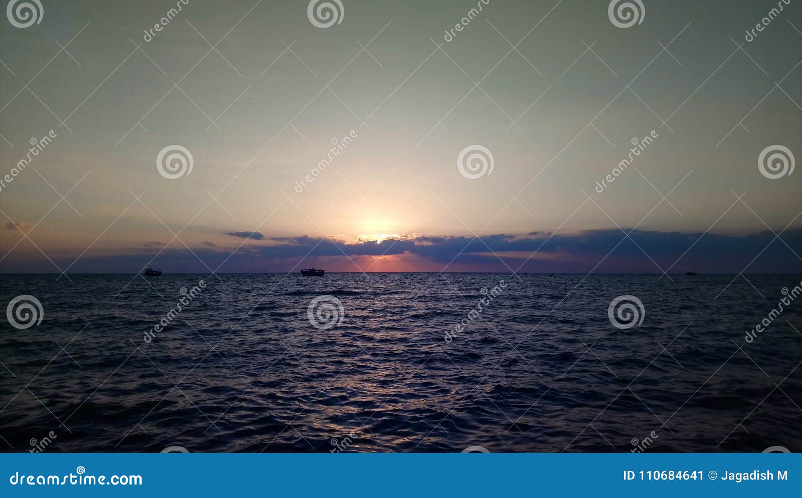beautiful view of sun hiding behind clouds during sunrise at rameswaram,india