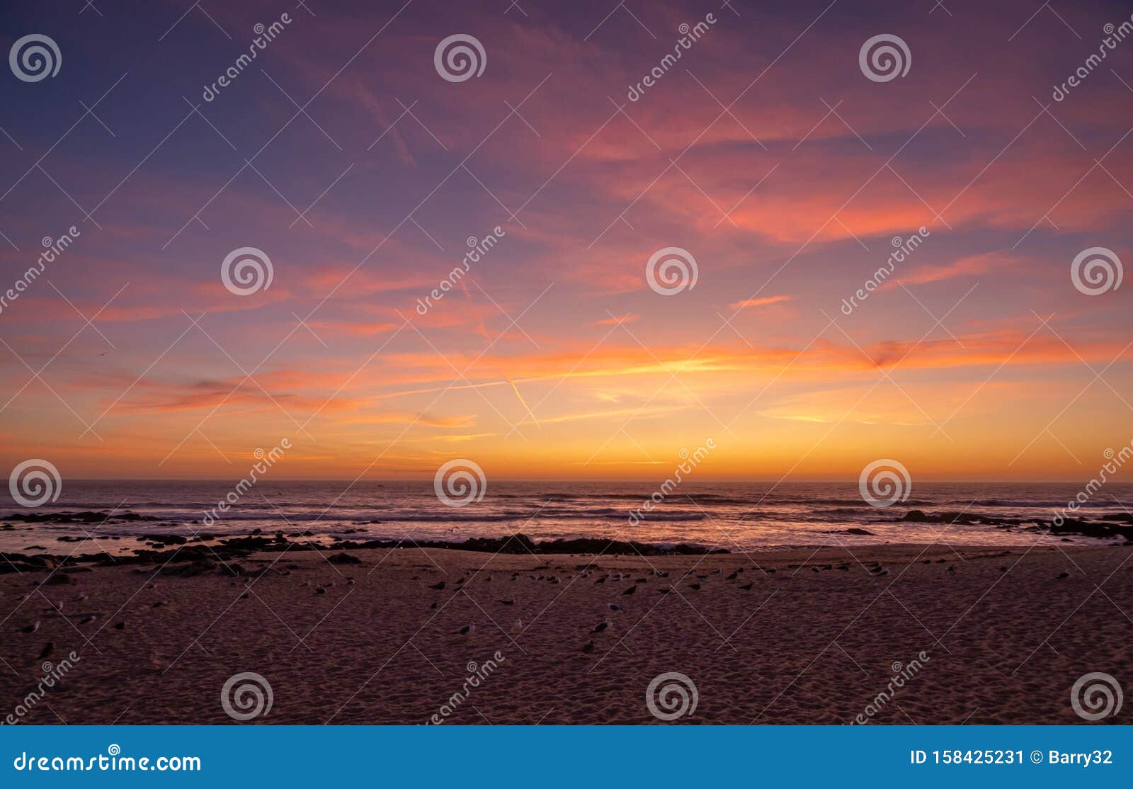 Beautiful Vivid Sunset Sky Over Ocean With Red Clouds And Blue Yellow