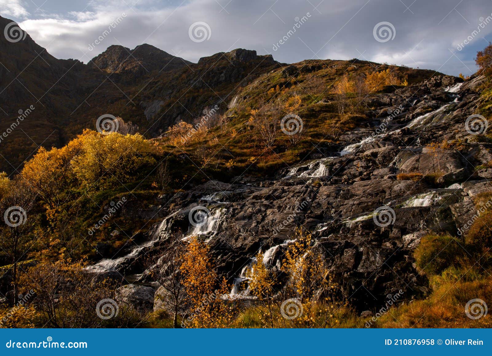 beautiful waterfalls in autumn colors located in lofoten, norway - waterfall panorama on moskenesoya, lofoten, norway