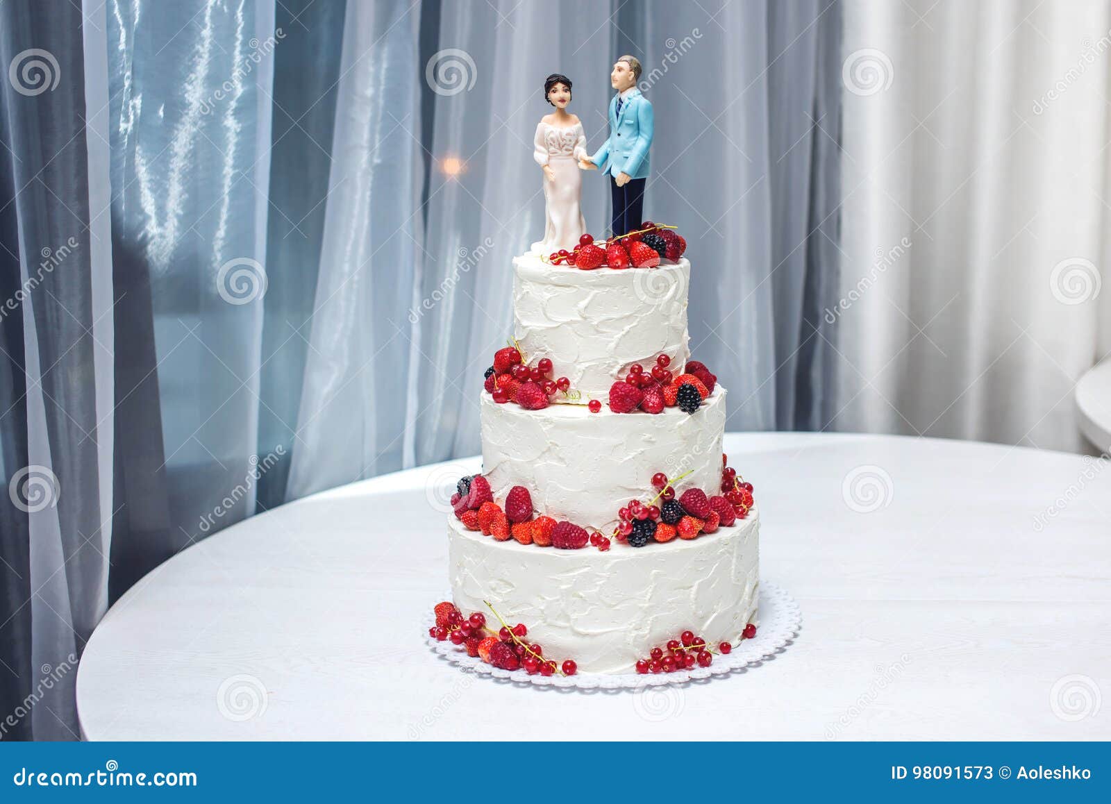 Wedding Cake With Figurines Of The Bride And Groom On Top