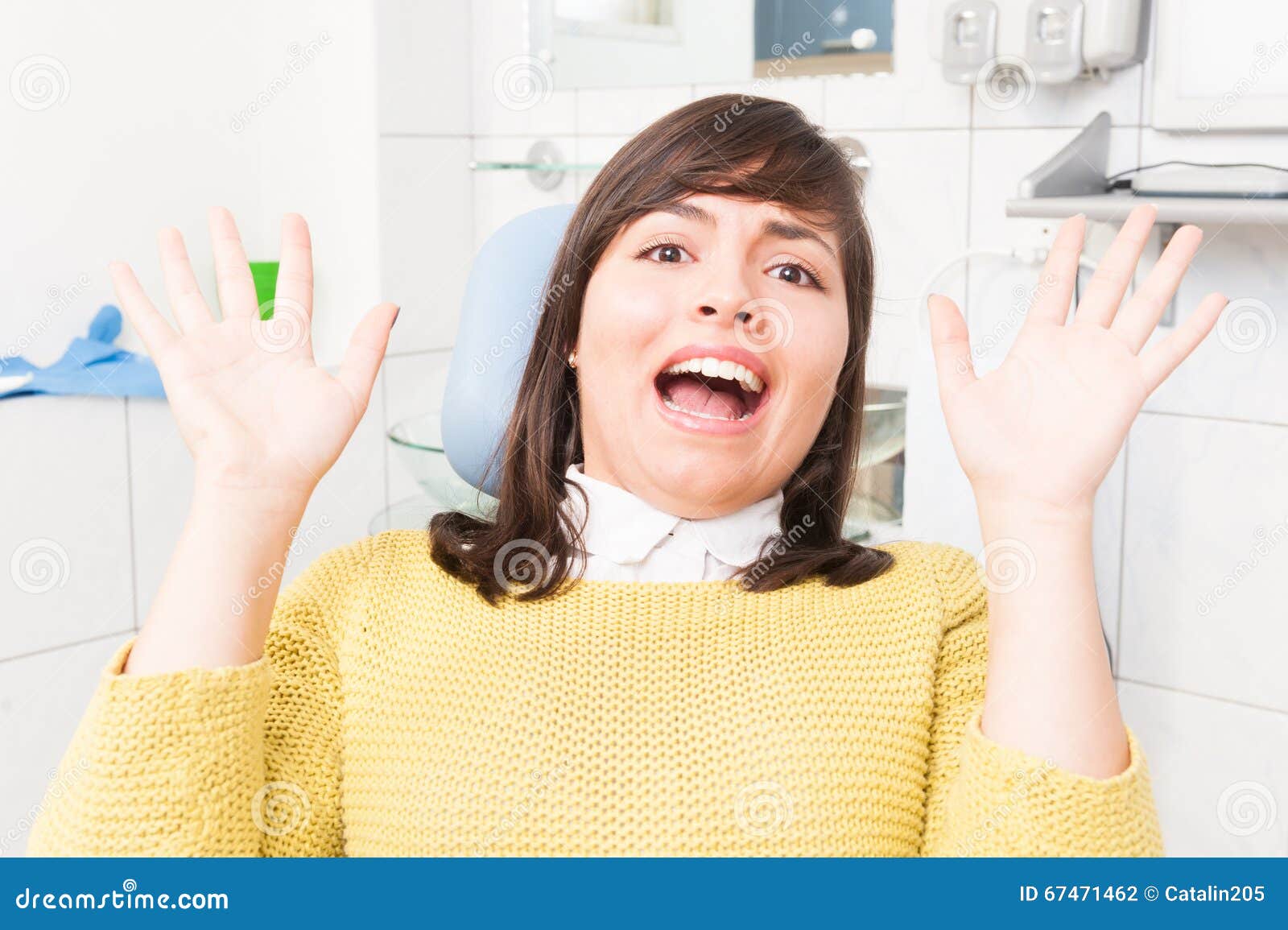 beautiful woman acting terrify while sitting on dental chair