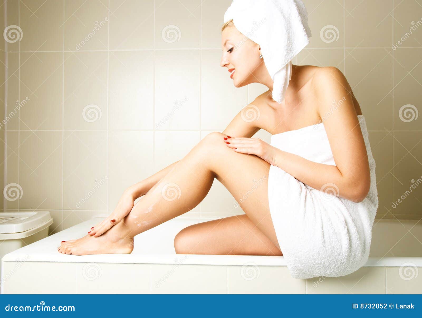beautiful woman applying body lotion