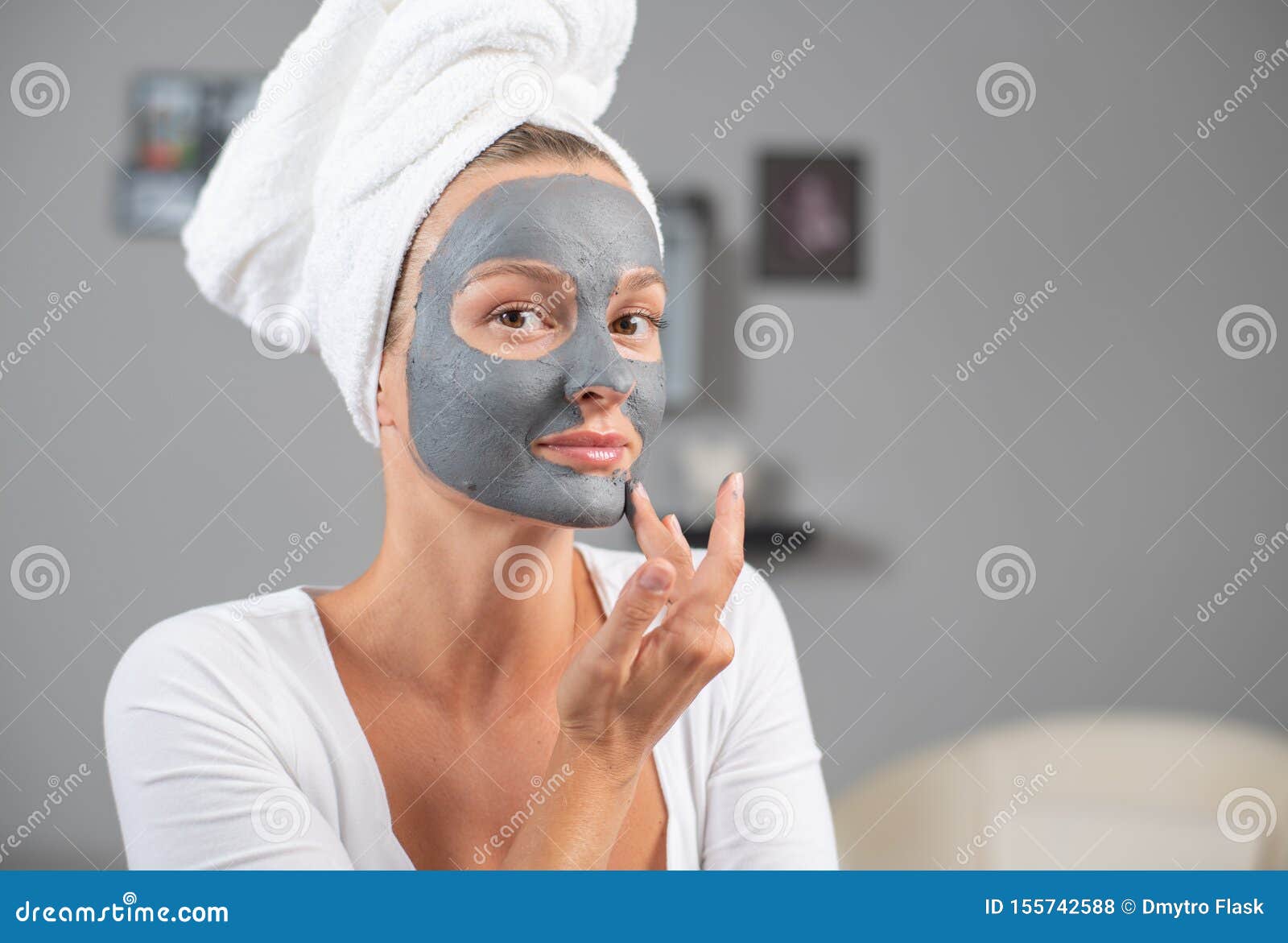 Beautiful Woman is Applying Facial Clay Mask. Beauty Treatments and ...