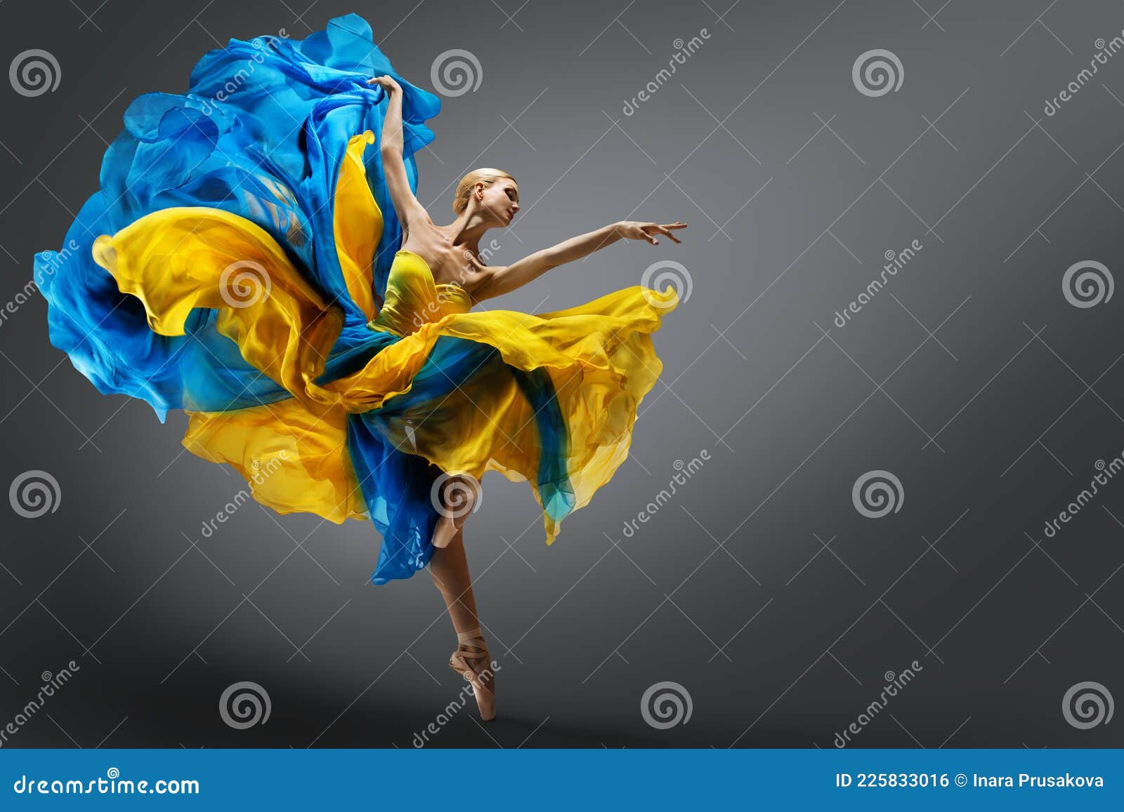 beautiful woman ballet dancer jumping in air in colorful fluttering dress. graceful ballerina dancing in yellow blue gown