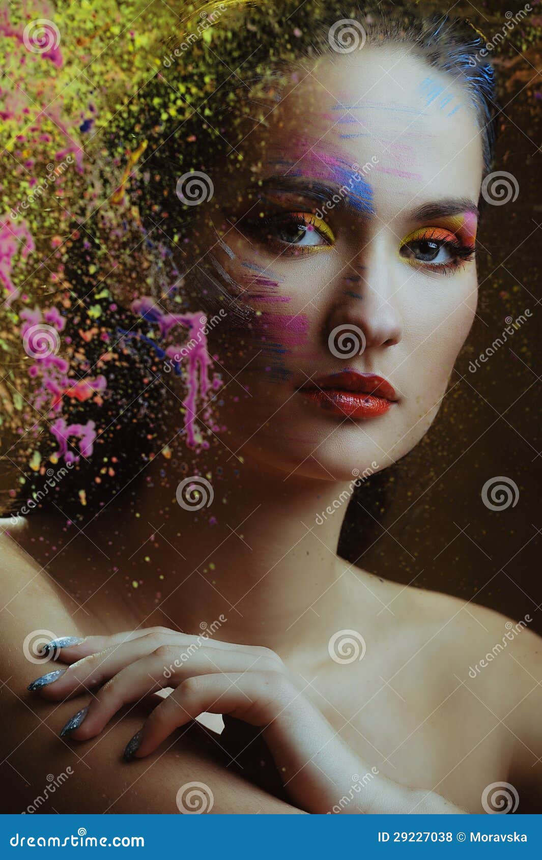 beautiful woman in color paint splash behind the painted color glass