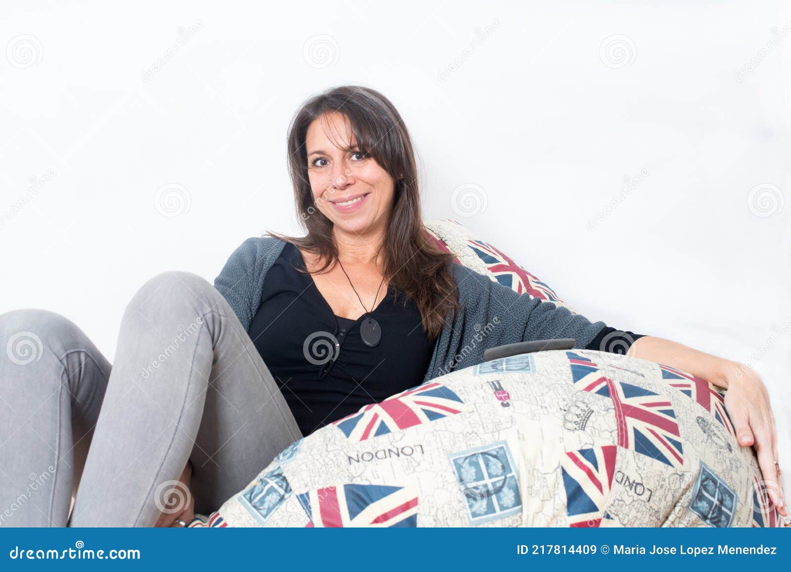 beautiful woman 30-40 on a confortable sofa with british printart looking to the camera