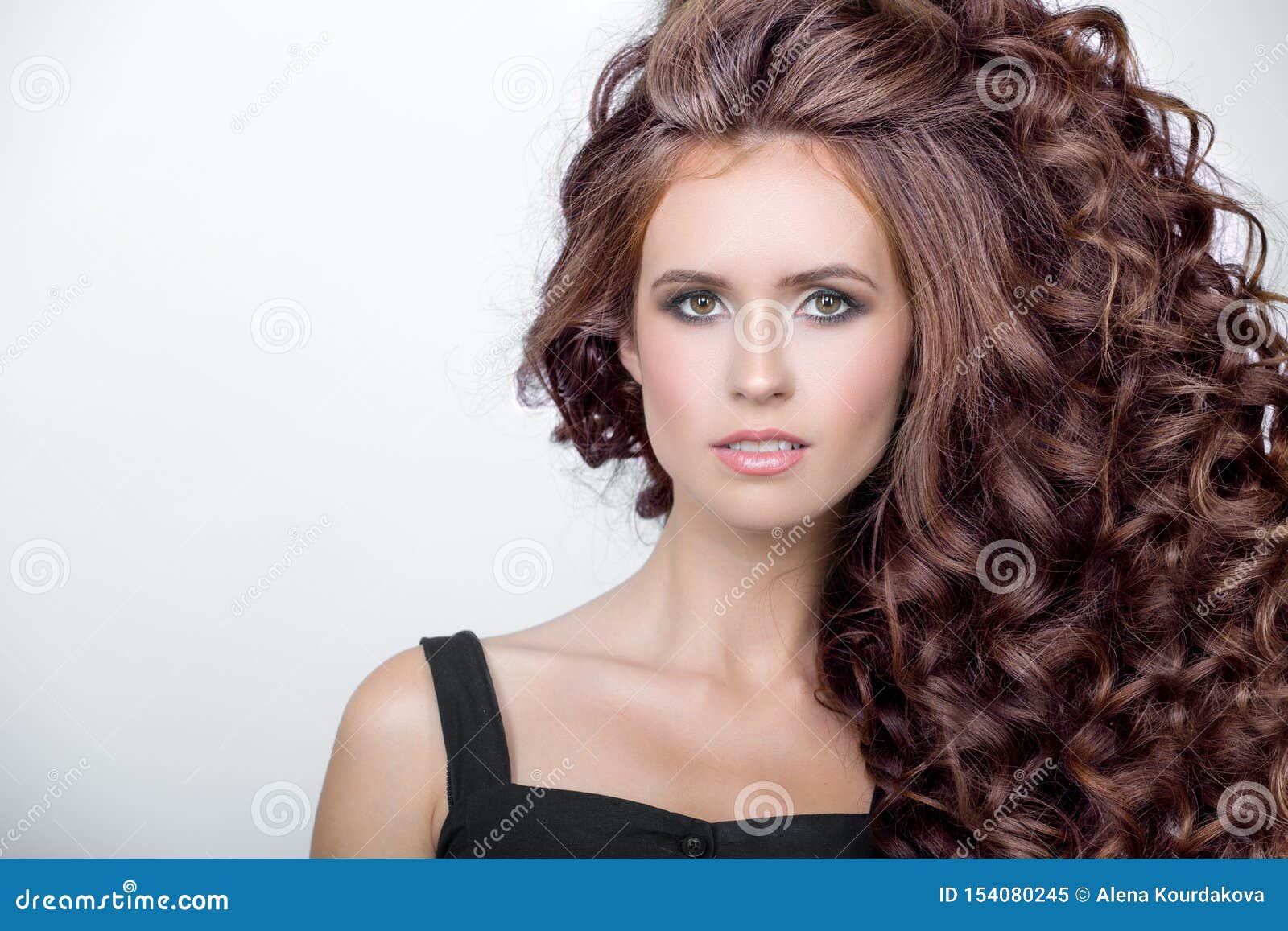 beautiful woman with curly brown thick hair. face closeup portrait
