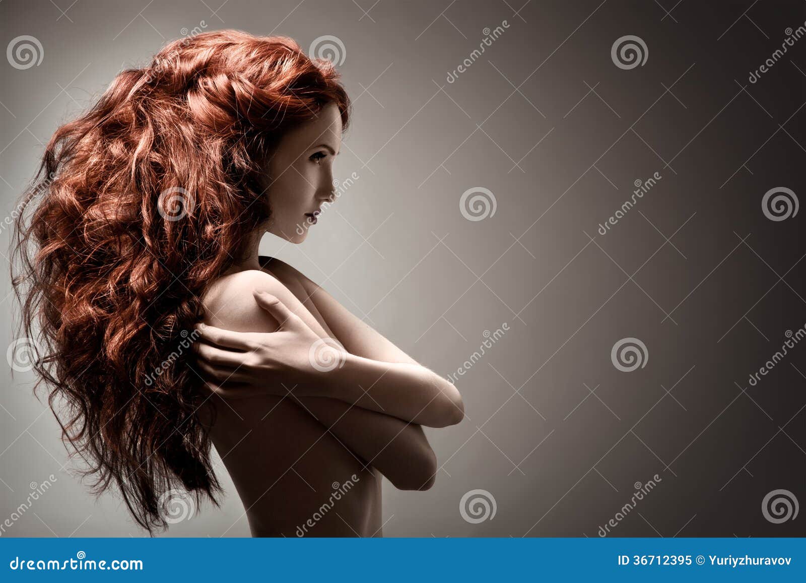 beautiful woman with curly hairstyle on gray background