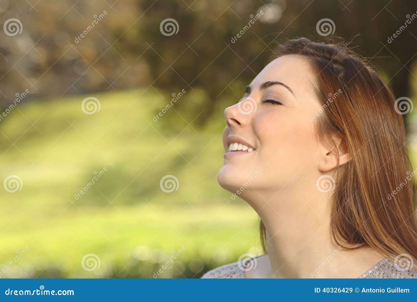 Beautiful woman doing breathing deep exercises in a park. Beautiful happy smiling woman doing breathing deep exercises in a warmth park green background