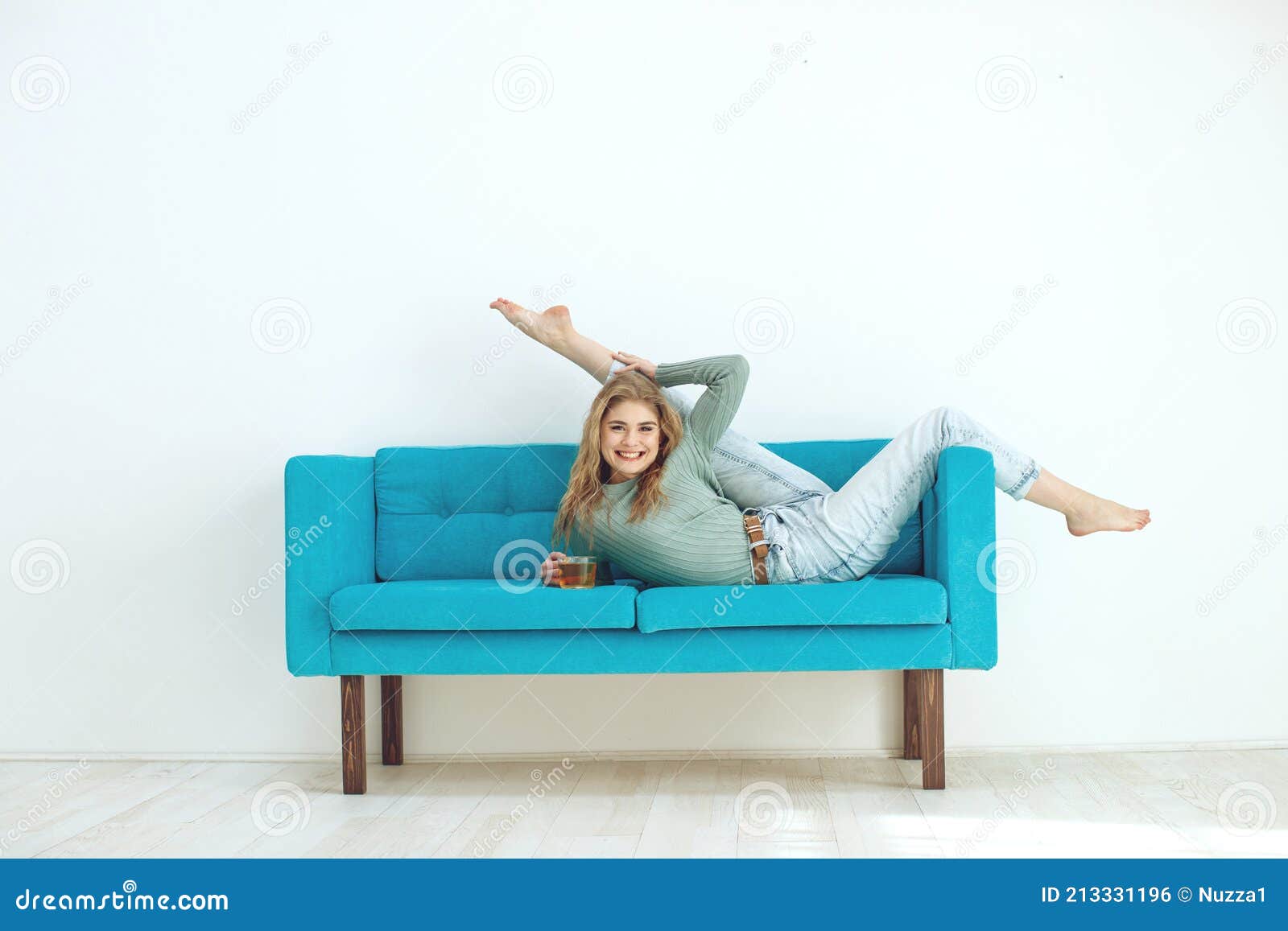 Beautiful Woman is Drinking Tea on the Sofa at Home. Sportive Young Girl  Doing Yoga Pose on the Couch Stock Photo - Image of cozy, comfort: 213331196