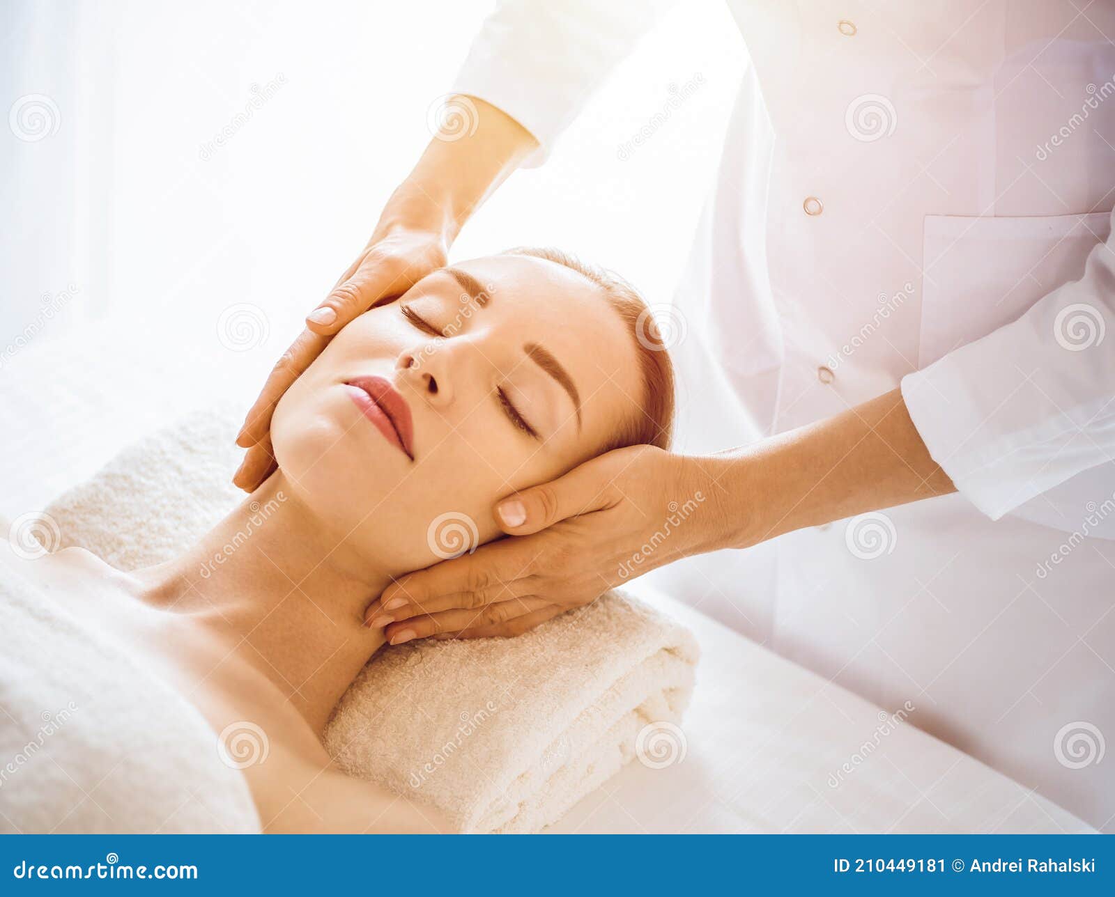 Beautiful Woman Enjoying Facial Massage With Closed Eyes In Sunny Spa Center Stock Image Image