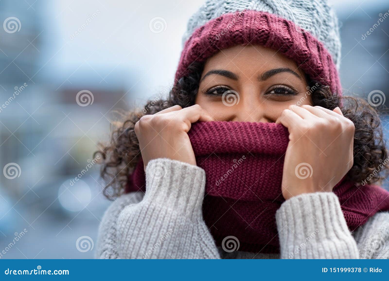 beautiful woman hiding face in woolen scarf