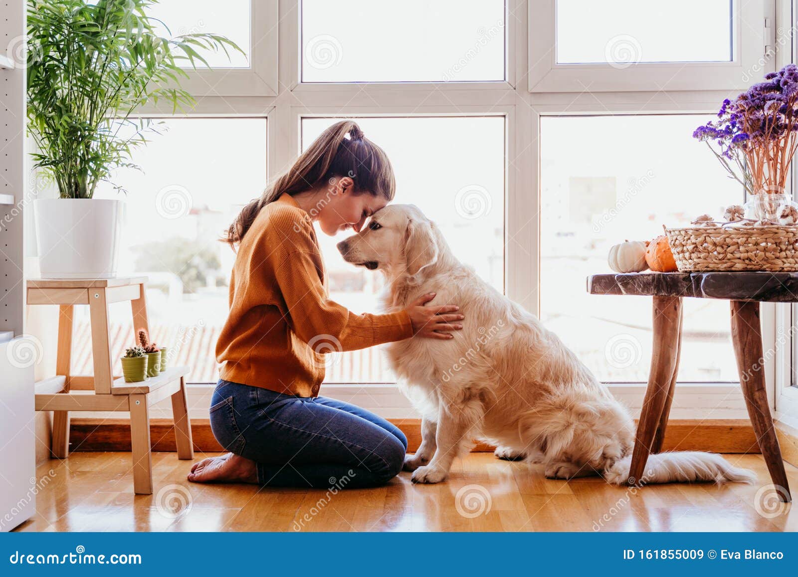 Beautiful Woman Hugging Her Adorable Golden Retriever Dog at Home. Love