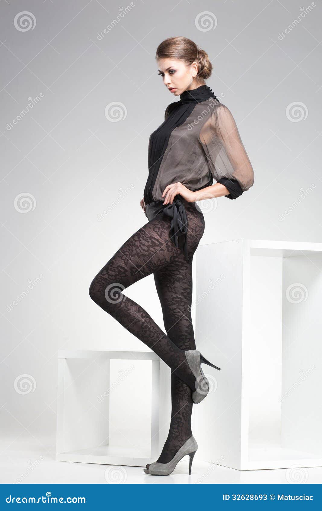 beautiful woman with long legs dressed elegant posing in the studio