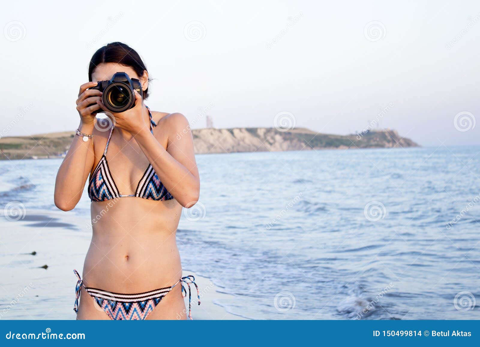 Beautiful Woman Photographer Takes Photos In Bikini On The Beach Stock
