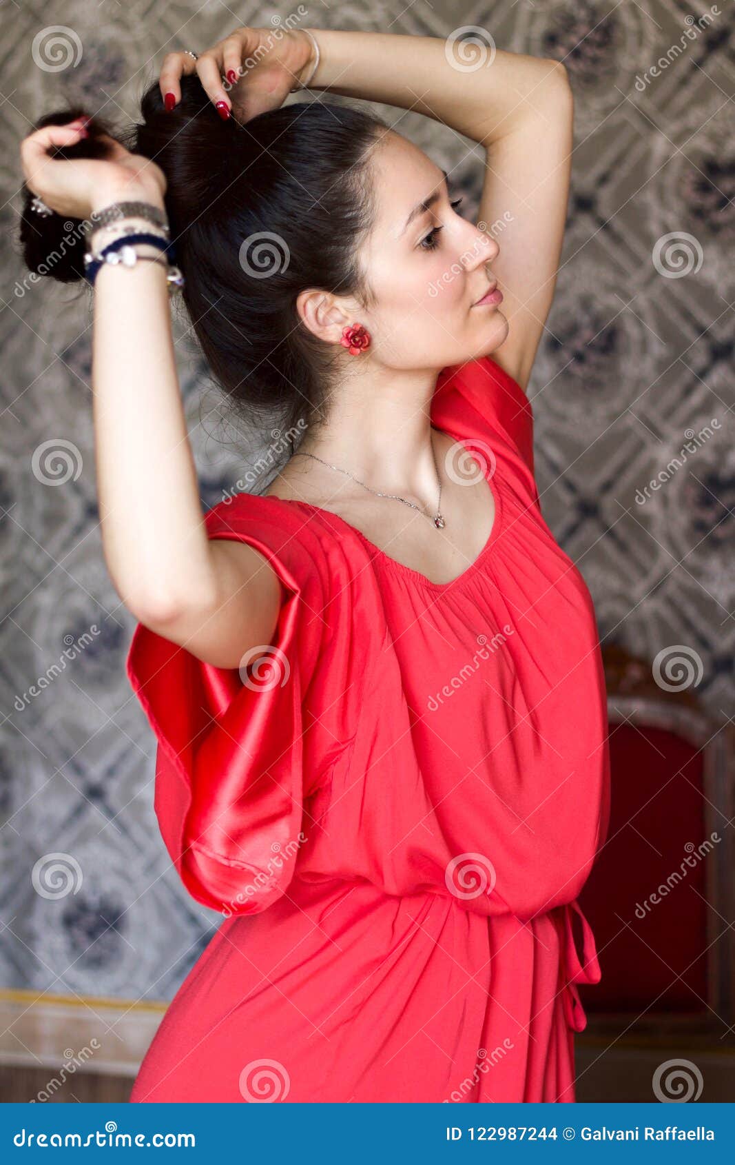 beautiful woman playing with her hair in coral satin dress