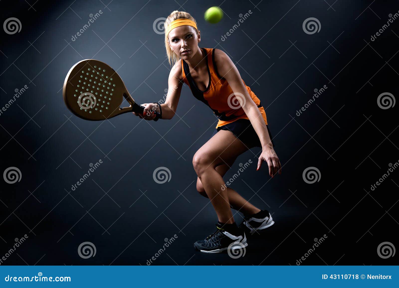 beautiful woman playing padel indoor.  on black.