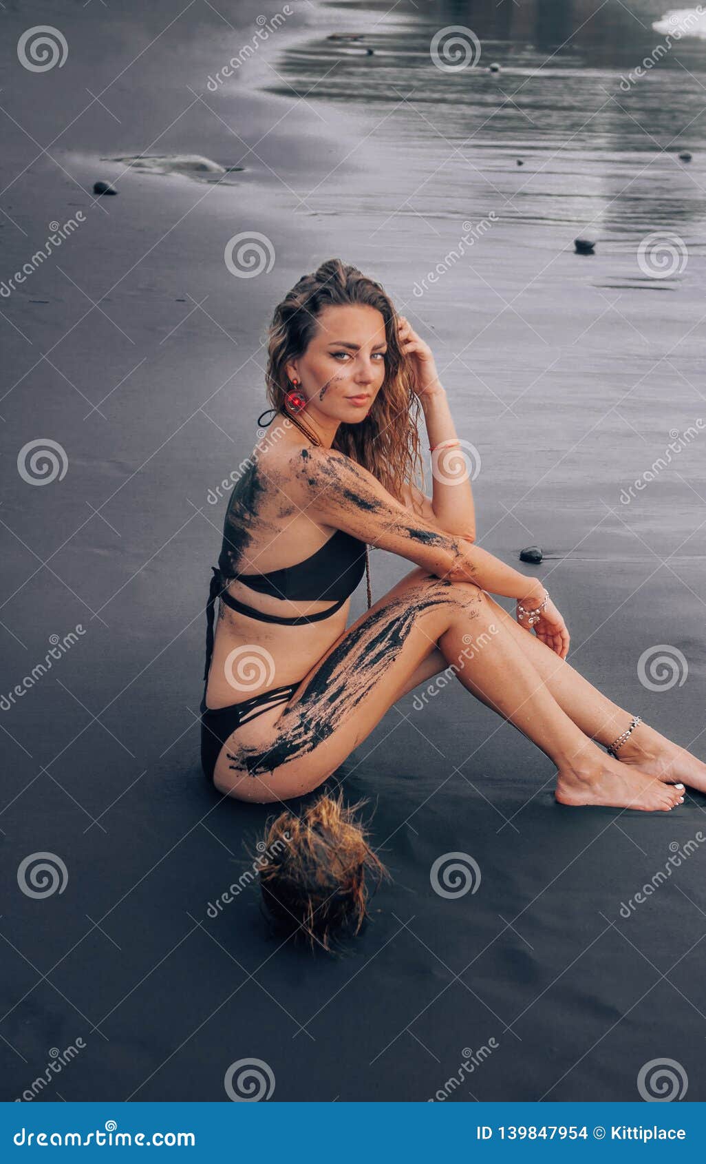 Beautiful Woman Posing On The Black Sand Beach In Bali