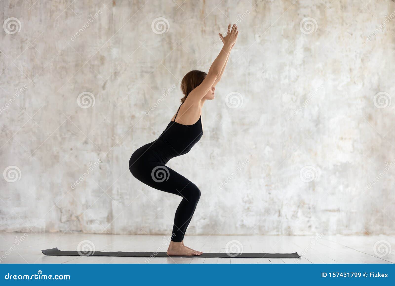 beautiful woman practicing yoga, chair exercise, utkatasana pose