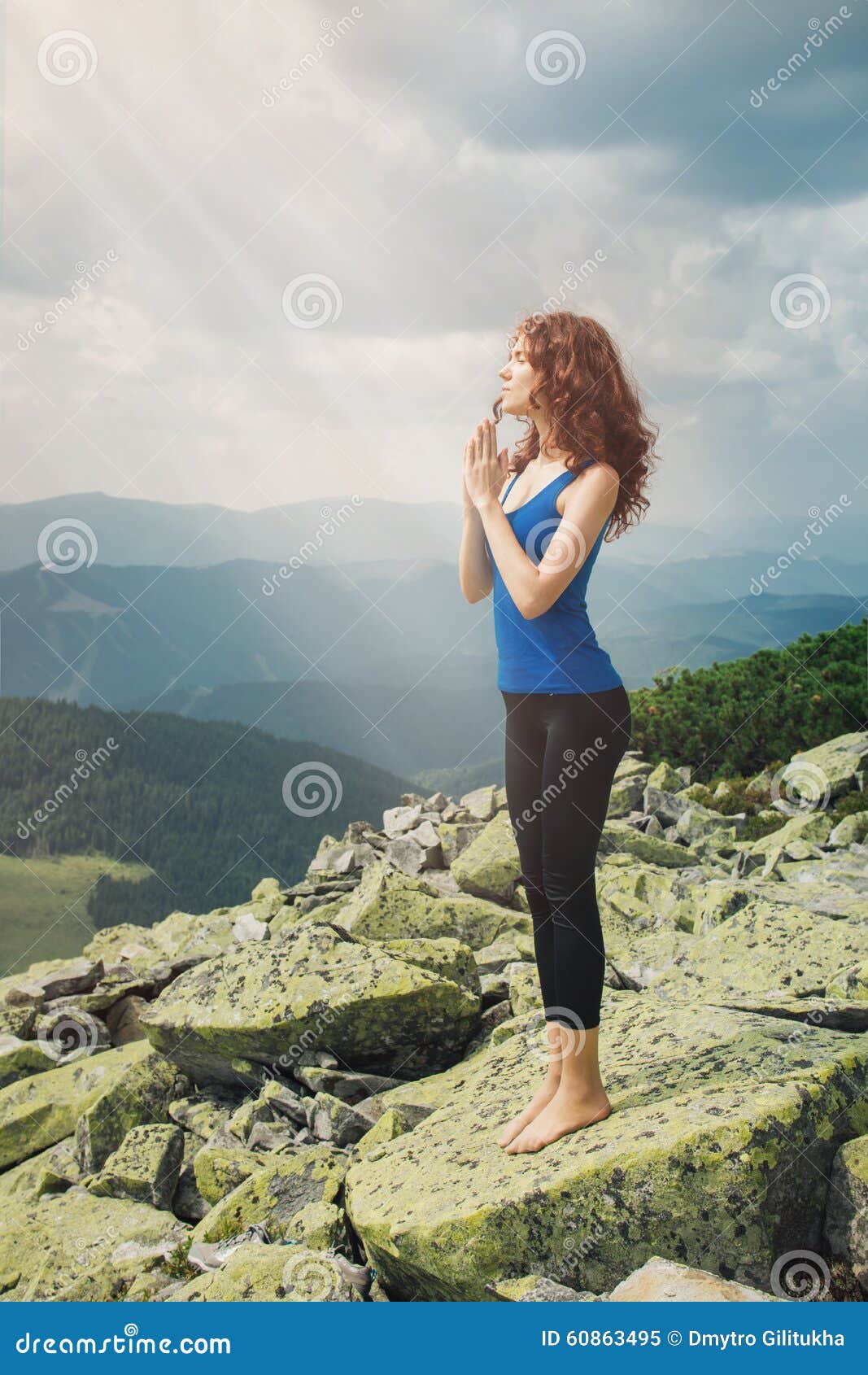 Beautiful woman praying in mountain landscape. Woman enjoy the beautiful view in the mountains and praying