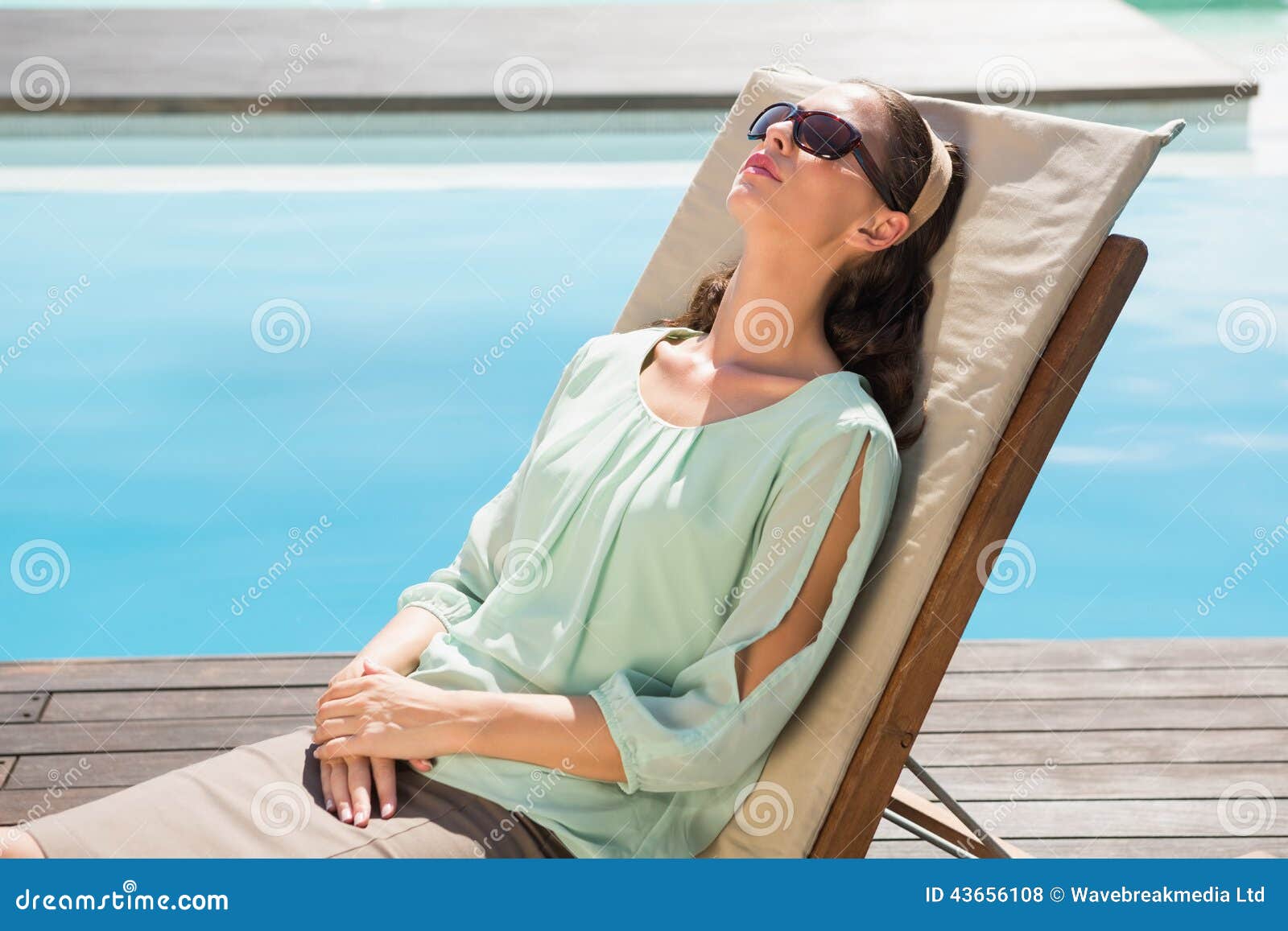 Beautiful Woman Relaxing on Sun Lounger by Swimming Pool Stock Photo ...