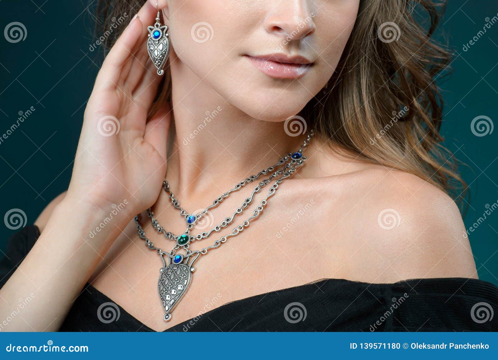 beautiful woman showing off her jewelery in fashion concept wearing accessories and jewelry  over dark background