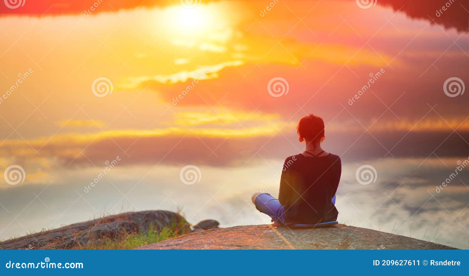 beautiful woman sits in a pose of a lotus on high place with amazing view of the lake sunset practice yoga meditation kundalini