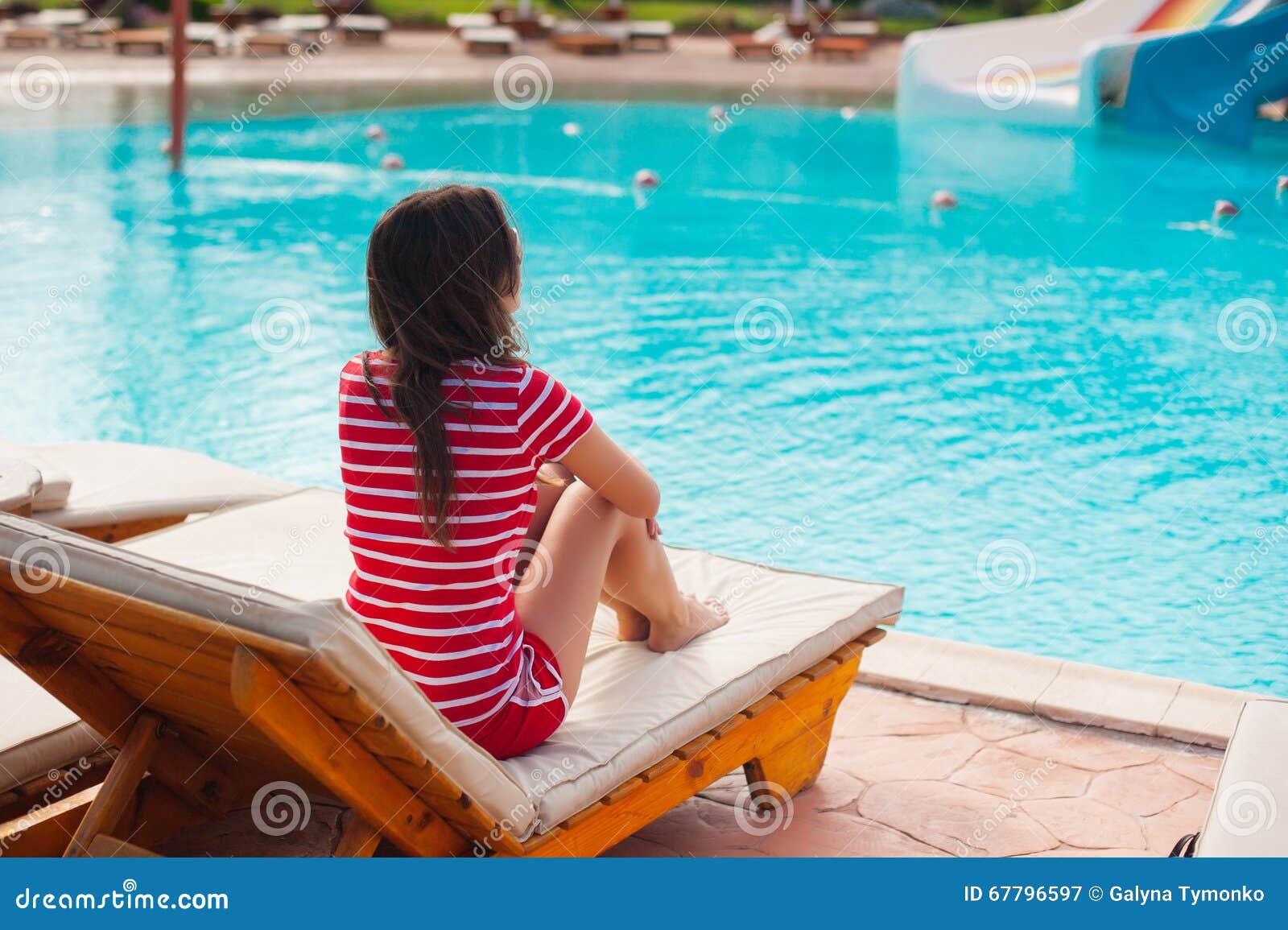 Beautiful Woman Sitting On A Lounger Pool Background Stock Image