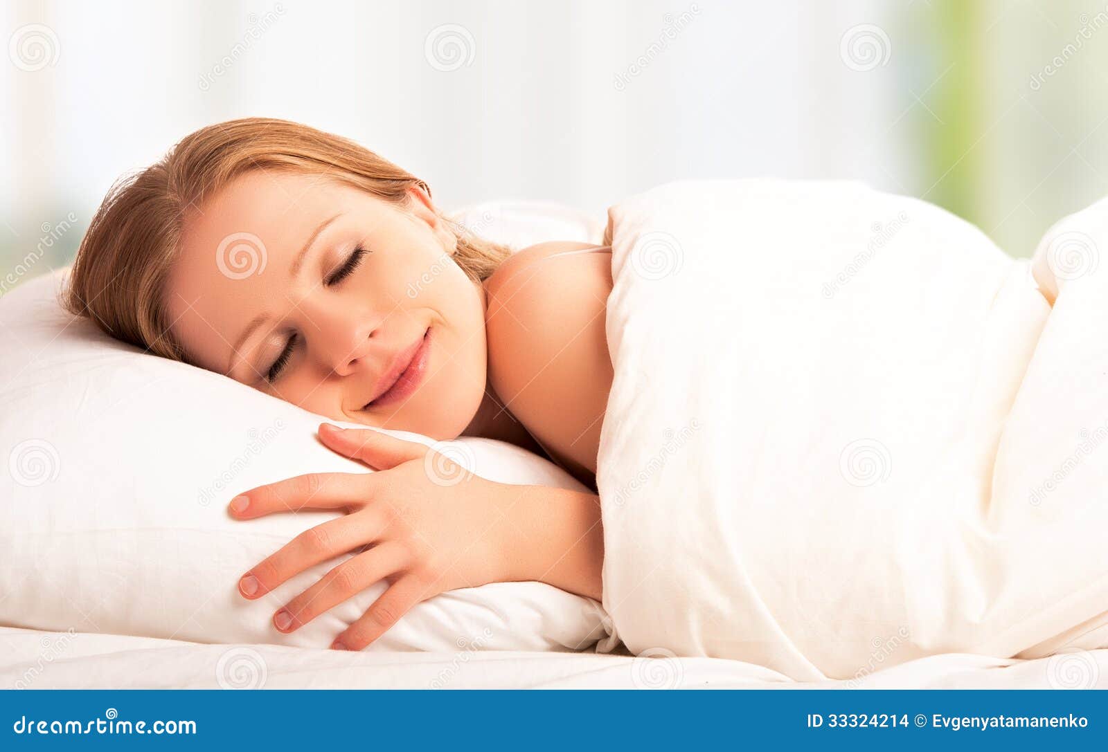 beautiful woman sleeping and smiles in his sleep in bed