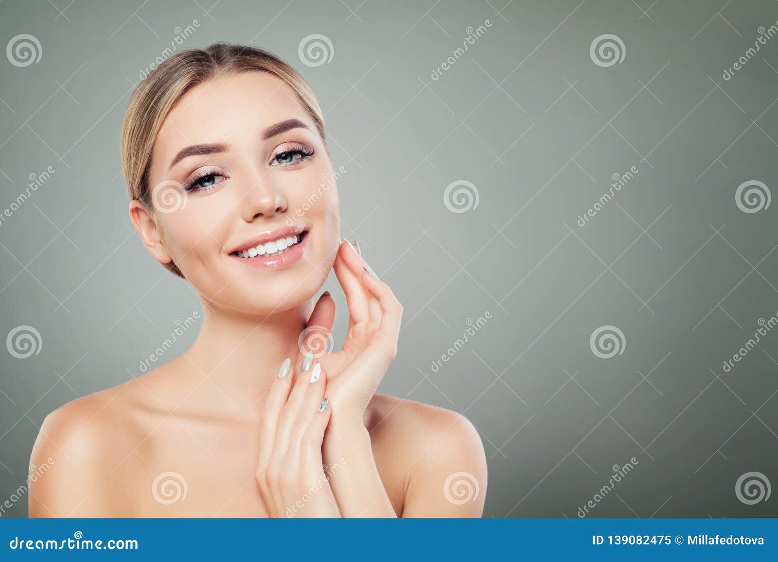 beautiful woman smiling and touching her hand her face. cute girl with clear skin. facial treatment, face lifting and cosmetology