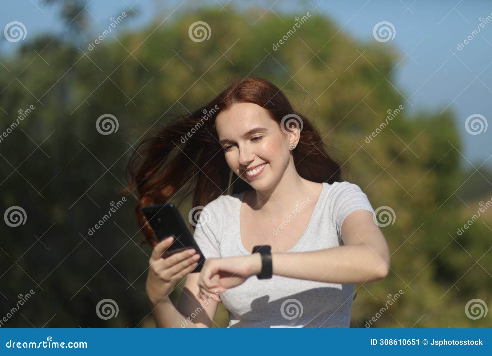 happy woman using a smartphone and a watch