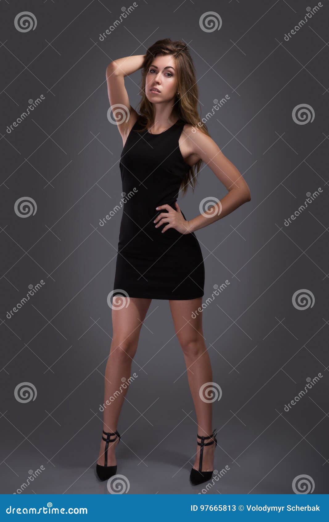 Beautiful Woman Standing in a Black Dress Over Gray Background Stock ...