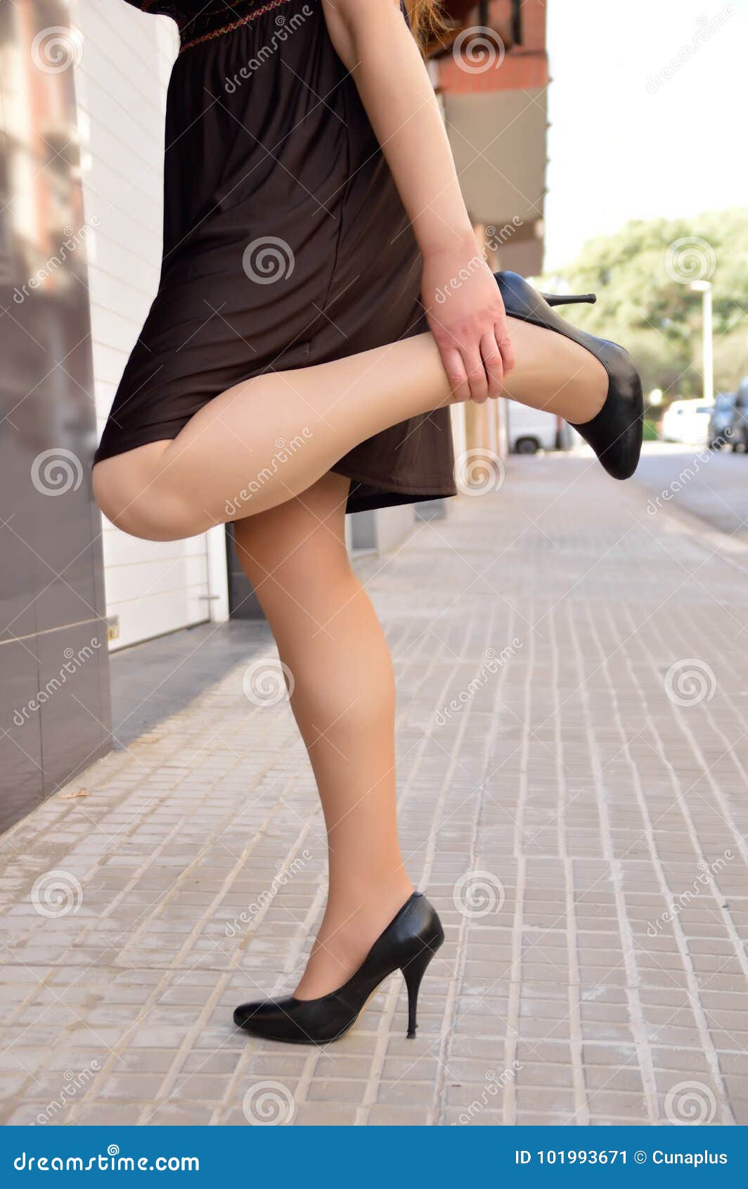 Woman suffering from pain in her legs and feet after walking on high heels  all day long Stock Photo - Alamy