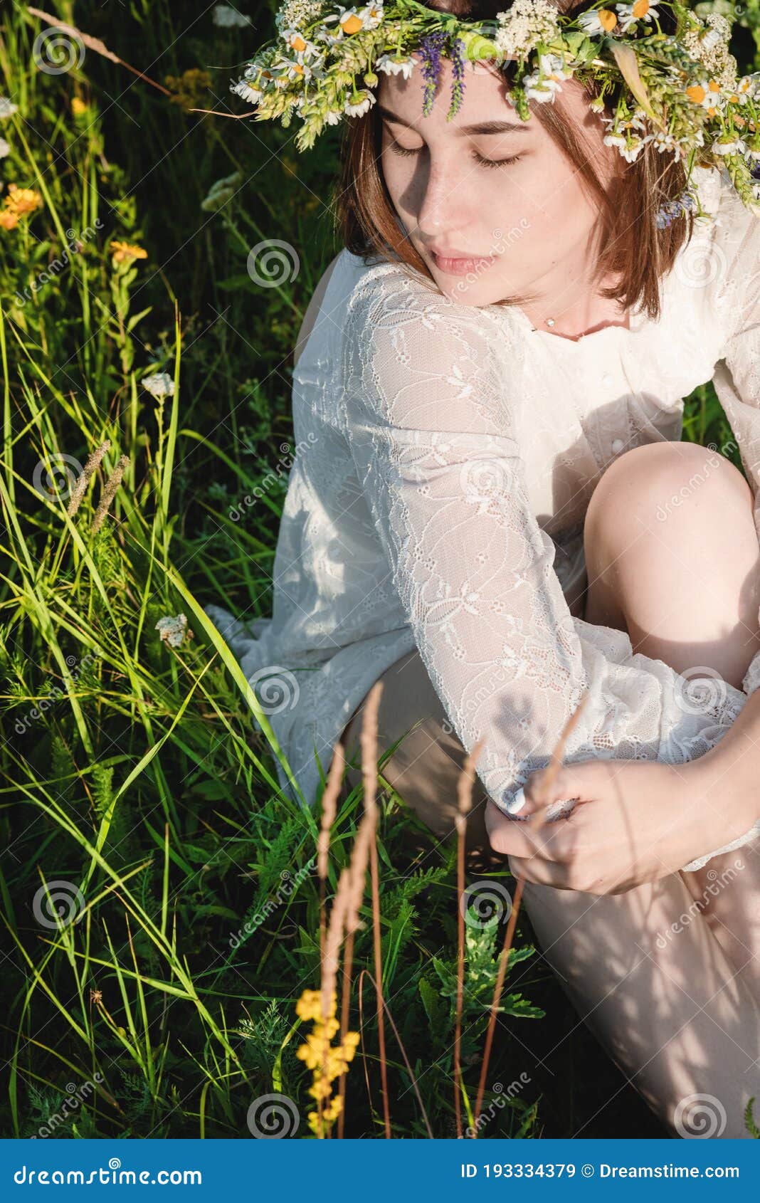 A Beautiful Woman In A White Dress In The Boho Style With A Wreath On Her Head Sitting In A